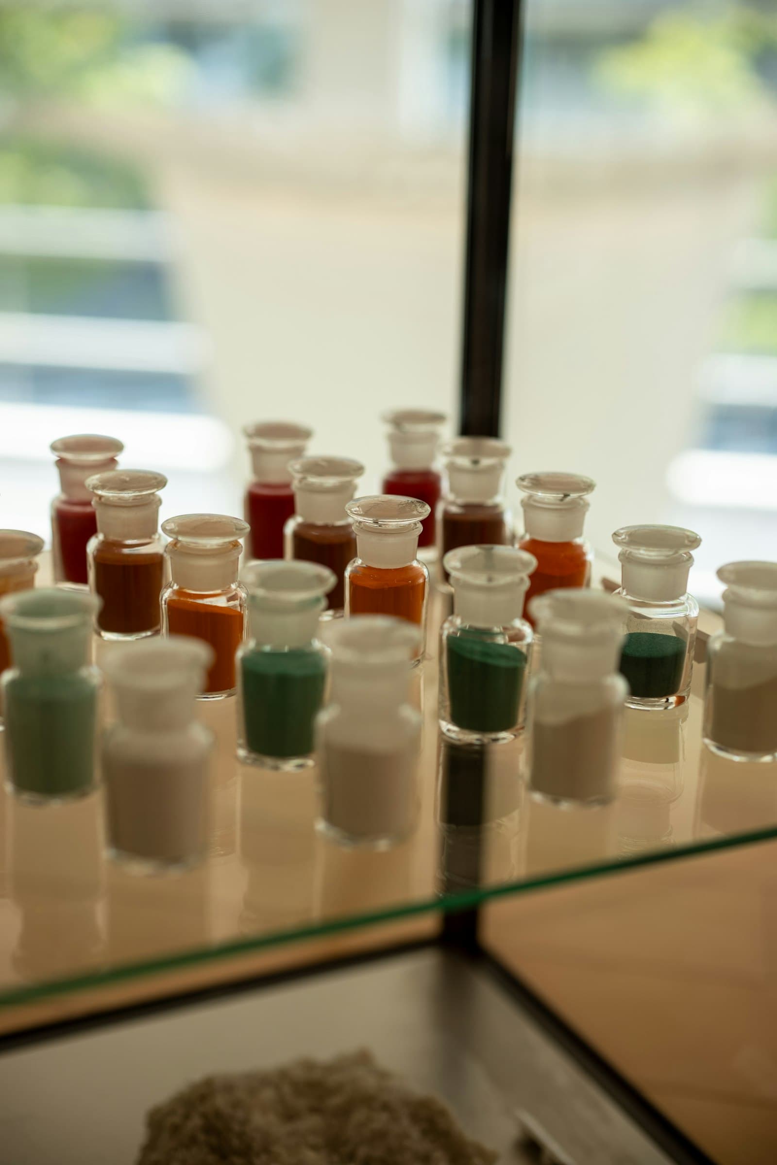 Small glass jars filled with coloured powders